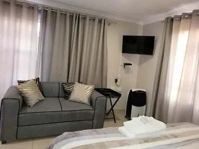 a living room with a couch and a bed at Makobaneng Guesthouse in Ga-Raphokola