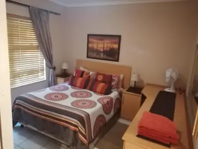 a bedroom with a large bed and a window at Inviting 3-Bed House in Kempton Park in Kempton Park