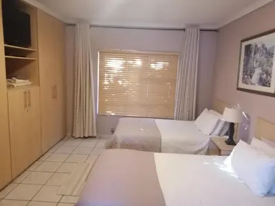 a hotel room with two beds and a window at Inviting 3-Bed House in Kempton Park in Kempton Park