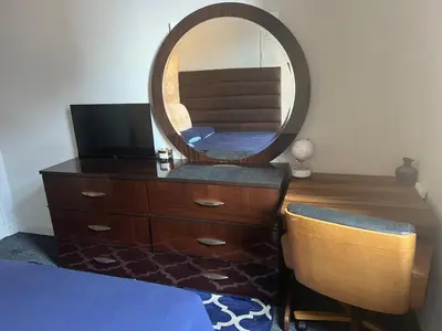a bedroom with a dresser with a mirror on it at Just a Room in Pretoria