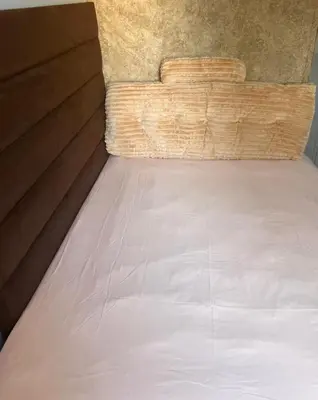 a bed in a room next to a wall at Just a Room in Pretoria