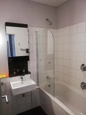 a bathroom with a sink and a shower and a tub at Just a Room in Pretoria