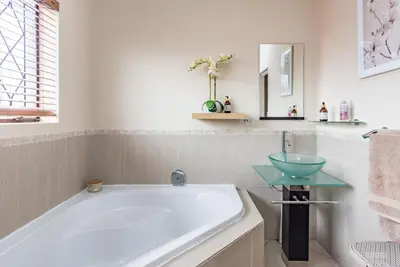 a bathroom with a tub and a sink at 150 Jacaranda Guesthouse in Midrand