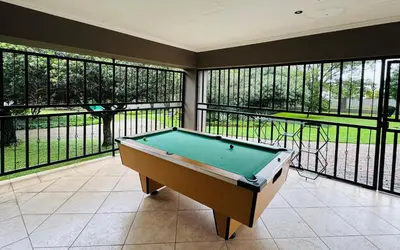 a pool table in a room with windows at 150 Jacaranda Guesthouse in Midrand