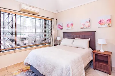 a bedroom with a large bed and a window at 150 Jacaranda Guesthouse in Midrand