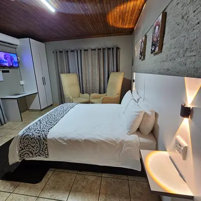 a hotel room with a bed and a tv at ZUCH Accommodation at Pafuri Self Catering in Polokwane