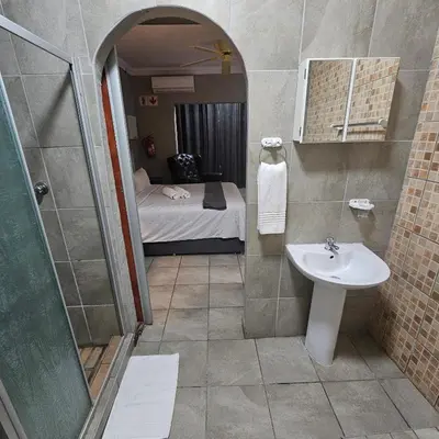 a bathroom with a sink and a bed in a room at ZUCH Accommodation at Pafuri Self Catering in Polokwane