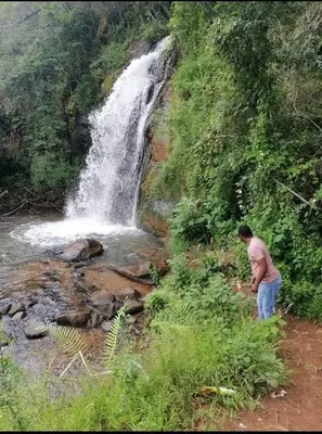 a man standing in front of a waterfall at Amaroks self catering units in Sabie