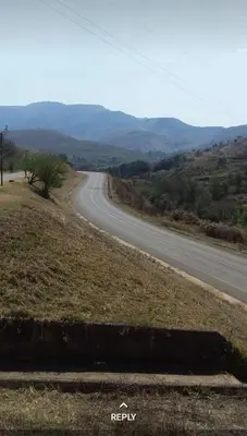 an empty road in the middle of a field at Amaroks self catering units in Sabie
