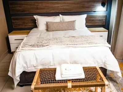 a bedroom with a large bed with a wooden headboard at Wilson Guest House in Groblersdal