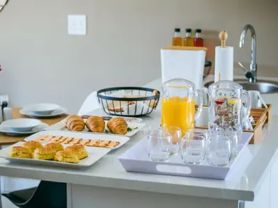 a table with two plates of food and orange juice at Wilson Guest House in Groblersdal