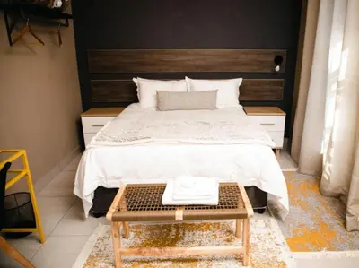 a bedroom with a large bed with a wooden headboard at Wilson Guest House in Groblersdal