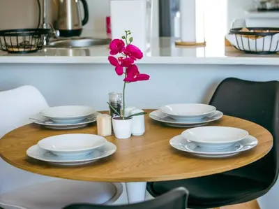 a wooden table with plates and a flower on it at Wilson Guest House in Groblersdal