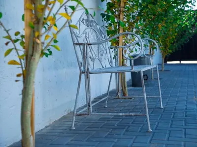a bench sitting on a sidewalk next to a wall at Wilson Guest House in Groblersdal