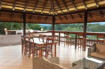a dining area with a table and chairs on a patio at Amazing mountain views! Solar powered! in Hoedspruit