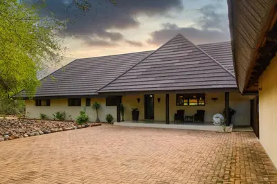 a house with a pitched roof and a brick driveway at Amazing mountain views! Solar powered! in Hoedspruit