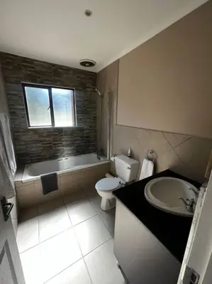 a bathroom with a sink and a toilet and a bath tub at 3-Bedroom House, Greenway Woods, White River in White River