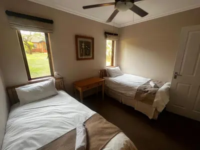 a bedroom with two beds and a ceiling fan at 3-Bedroom House, Greenway Woods, White River in White River