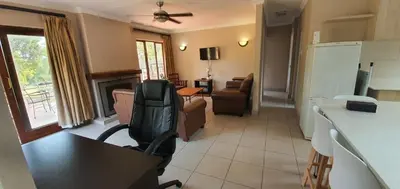 a living room with a chair and a table and a kitchen at 3-Bedroom House, Greenway Woods, White River in White River