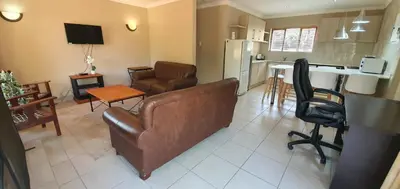 a living room with a couch and a kitchen at 3-Bedroom House, Greenway Woods, White River in White River