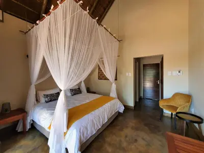 a bedroom with a bed with white mosquito netting at Masorini Bush Lodge & Safari Tents in Phalaborwa