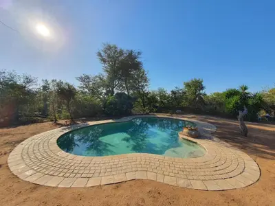 a small swimming pool in the middle of a field at Masorini Bush Lodge & Safari Tents in Phalaborwa