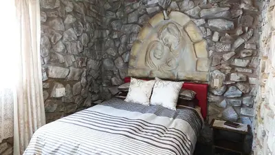 a stone wall with a bed in a room at The Shoe Guest House in Draasloot