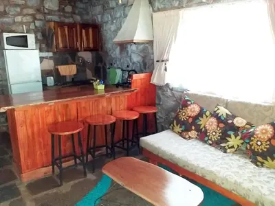 a kitchen with a bar with stools in a room at The Shoe Guest House in Draasloot