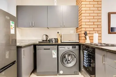 a kitchen with a washing machine and a washer at Resting nest waterfall in Midrand