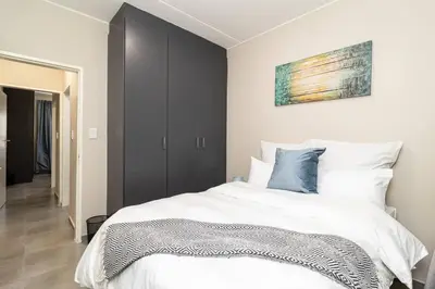 a bedroom with a large white bed with blue pillows at Resting nest waterfall in Midrand