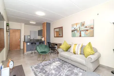a living room with a couch and a table at Resting nest waterfall in Midrand
