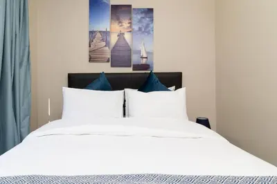 a bed with white sheets and blue pillows at Resting nest waterfall in Midrand