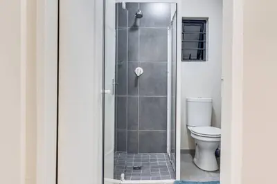 a glass shower in a bathroom with a toilet at Resting nest waterfall in Midrand