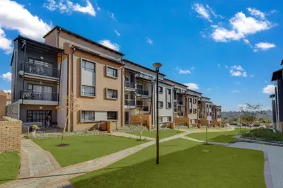 an apartment building with a lawn in front of it at Resting nest waterfall in Midrand