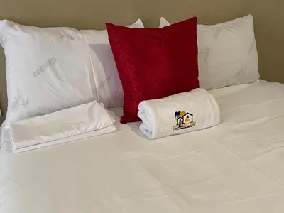 a white bed with two pillows and a white towel at Unit G Guest House in Ga-Mothiba