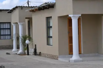 a building with columns and a door on a street at Unit G Guest House in Ga-Mothiba
