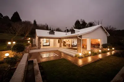 a house with a pool in the yard at night at Viewpoint Estate Accommodation in Haenertsburg