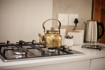 a tea kettle sitting on top of a stove at Viewpoint Estate Accommodation in Haenertsburg
