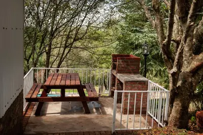 a picnic table and a bench next to a fence at Viewpoint Estate Accommodation in Haenertsburg