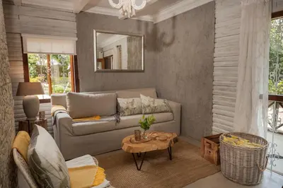 a living room with a couch and a table at Viewpoint Estate Accommodation in Haenertsburg