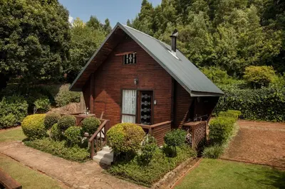 a small wooden house with a roof at Viewpoint Estate Accommodation in Haenertsburg