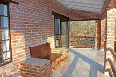 a wooden bench sitting on a brick wall at Villa de Leeu, Perfect for Two in Marloth Park
