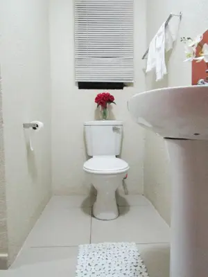 a white bathroom with a toilet and a sink at Khaya Guesthouse in Soshanguve