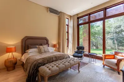 a bedroom with a bed and a large window at Lejwe La Metsi Self-Catering Villa in Bela-Bela