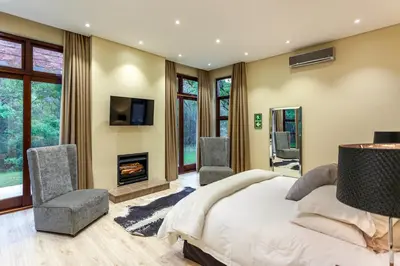 a bedroom with a bed and a fireplace at Lejwe La Metsi Self-Catering Villa in Bela-Bela