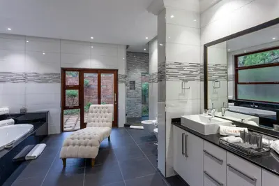 a bathroom with two sinks and a tub and a toilet at Lejwe La Metsi Self-Catering Villa in Bela-Bela