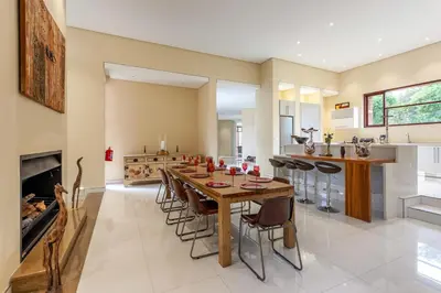 a kitchen and dining room with a wooden table and chairs at Lejwe La Metsi Self-Catering Villa in Bela-Bela