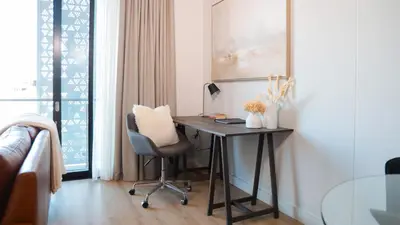 a desk in a room with a chair and a window at Luxury Apartment at Ellipse Waterfall, Midrand Near Mall of Africa in Midrand