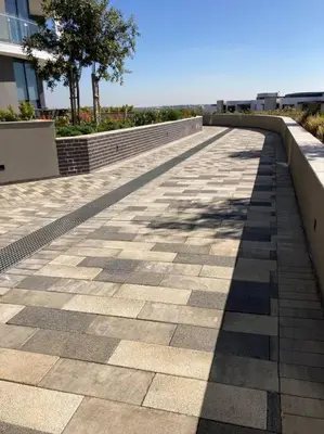 a walkway with a shadow of a tree on it at Luxury Apartment at Ellipse Waterfall, Midrand Near Mall of Africa in Midrand