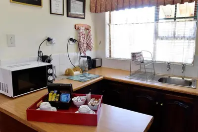 a kitchen with a counter top with a microwave at Villa Moria Memoir Cottage in Dullstroom